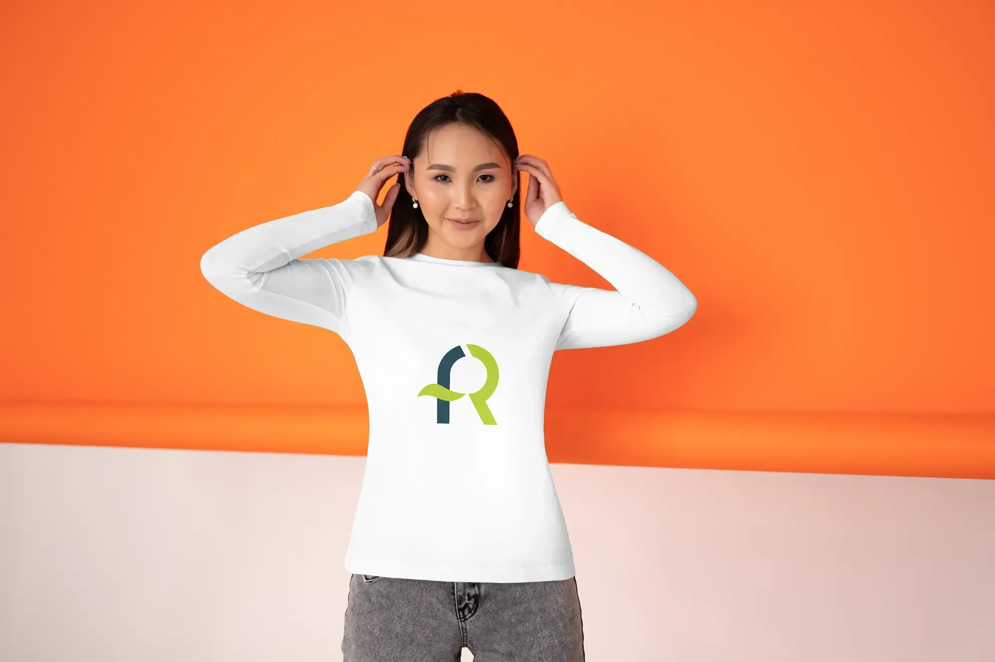 Persona con camiseta blanca que muestra el logotipo de AFR Diseño & Impresión sobre un fondo naranja.