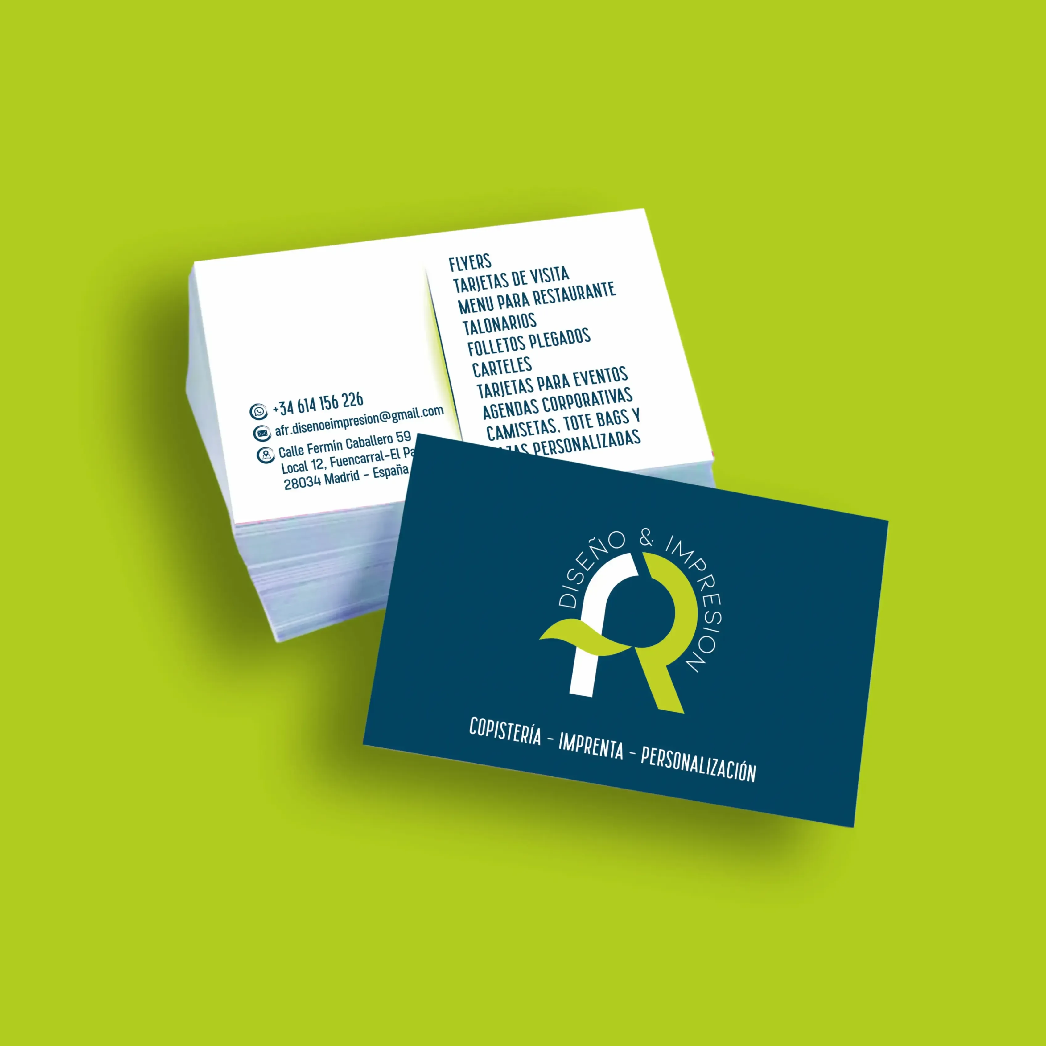 Tarjetas de visita apiladas sobre un fondo verde, mostrando diseño y datos de contacto.
