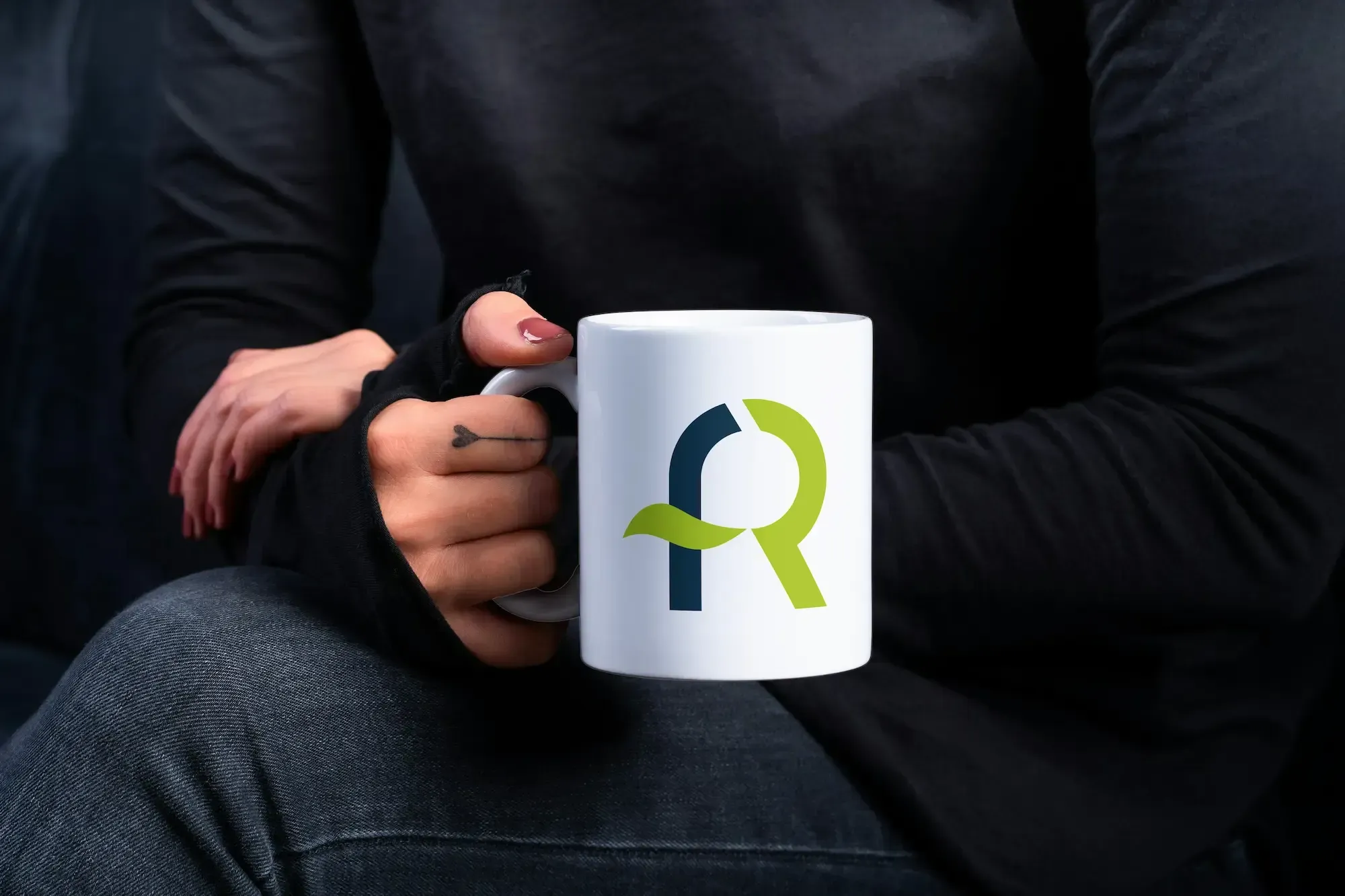 Persona sosteniendo una taza blanca con el logotipo de AFR Diseño & Impresión.